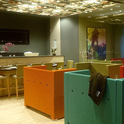 Zona bar moderna con illuminazione decorativa e arredi colorati - impianto elettrico e luci a basso consumo progettati da Disco Express