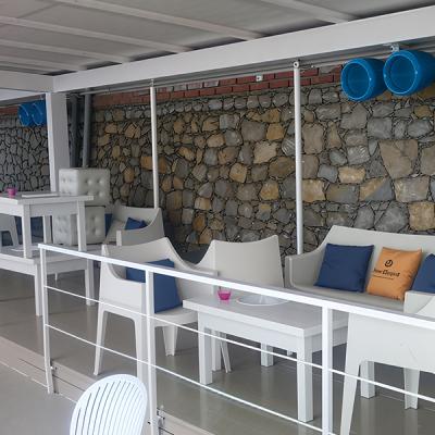 Zona lounge in ambiente esterno con diffusori acustici installati a soffitto - impianto audio per struttura turistica realizzato da Disco Express